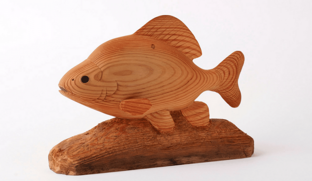 A photo of a fish carved out of wood.
