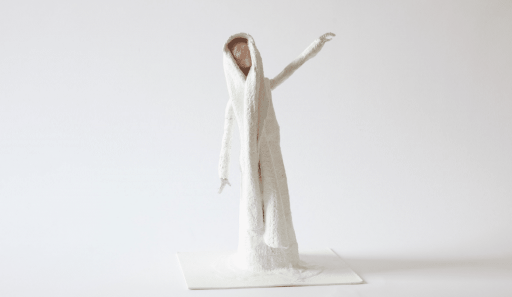 A photo of a sculpture of a person wearing white.