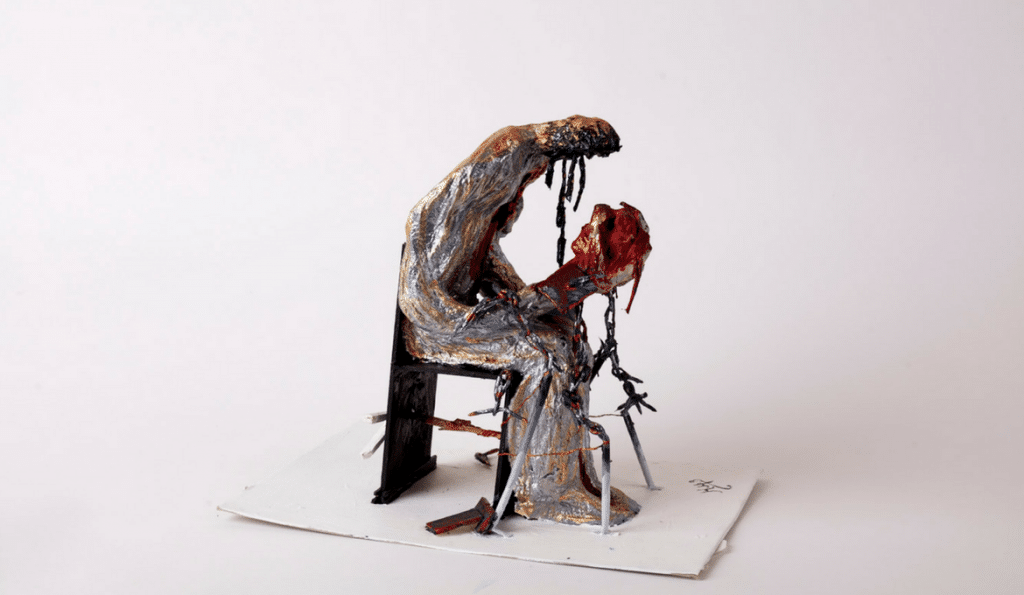 A sculpture of a person crouched over.