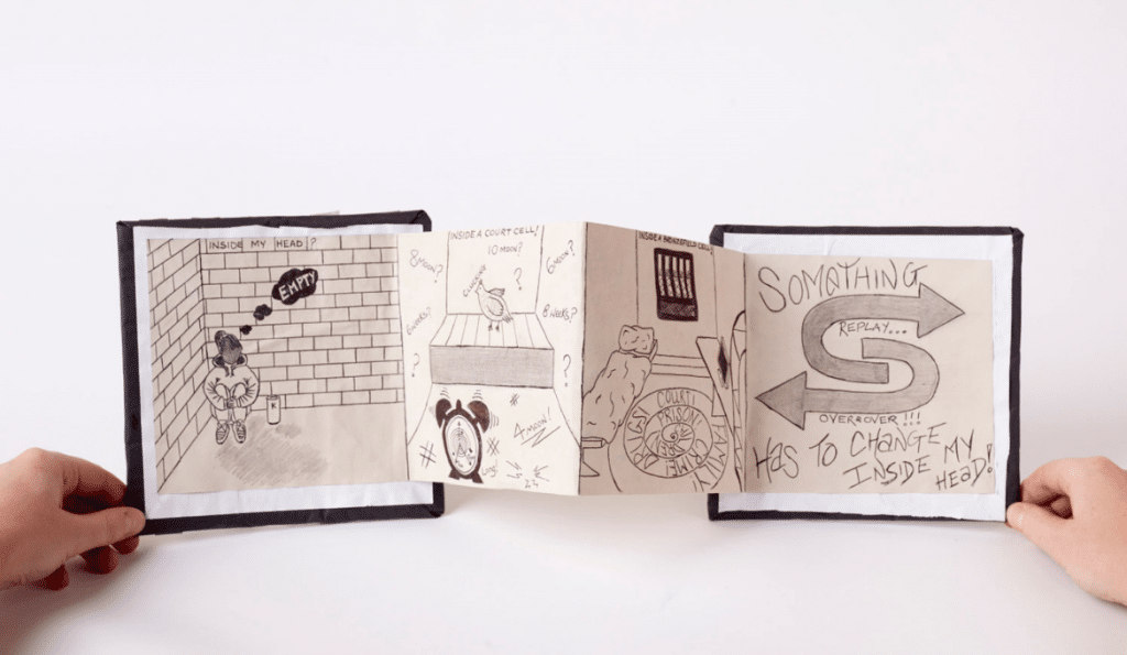 A photo of a handmade paper book with drawings in it.