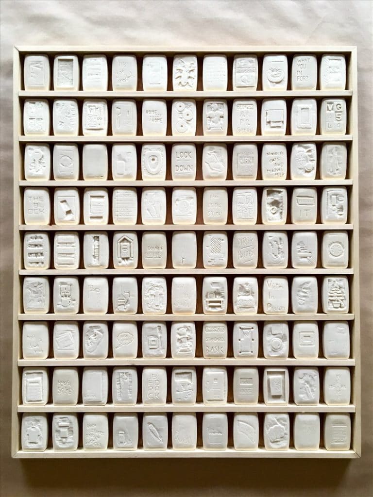 A photo of 99 pieces of soap carved into by artist Lee, each soap depicts a memory from his time in prison.