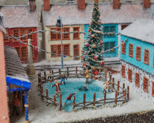 A miniature version of a Christmas scene of a family at an ice rink.