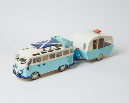 A photo of a miniature camper van with a Scottish flag on top.