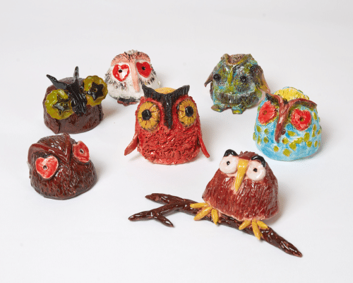 A photo of sculptures depicting little owls in with various colourings and features.