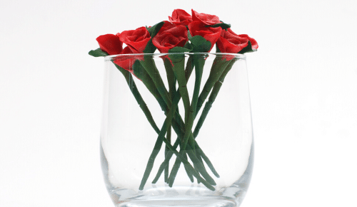 A painting of roses in a see-through vase.