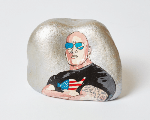 A photo of a silver tooth with a bald man with an American flag on his top.