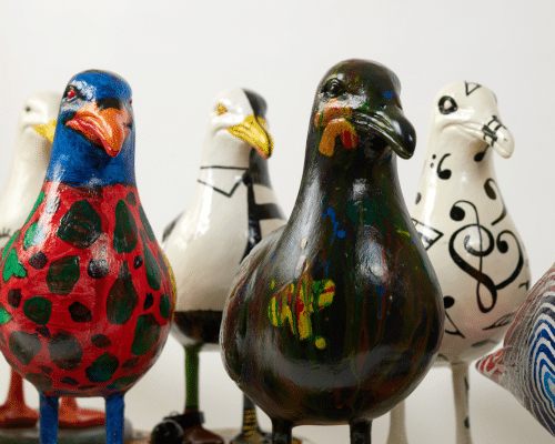 A photo of a group of colourful seagull sculptures.