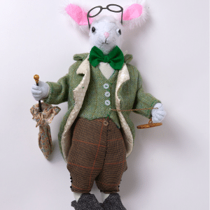 Old style rabbit soft toy dressed as traditional gentleman with glasses, umbrella and bow tie.